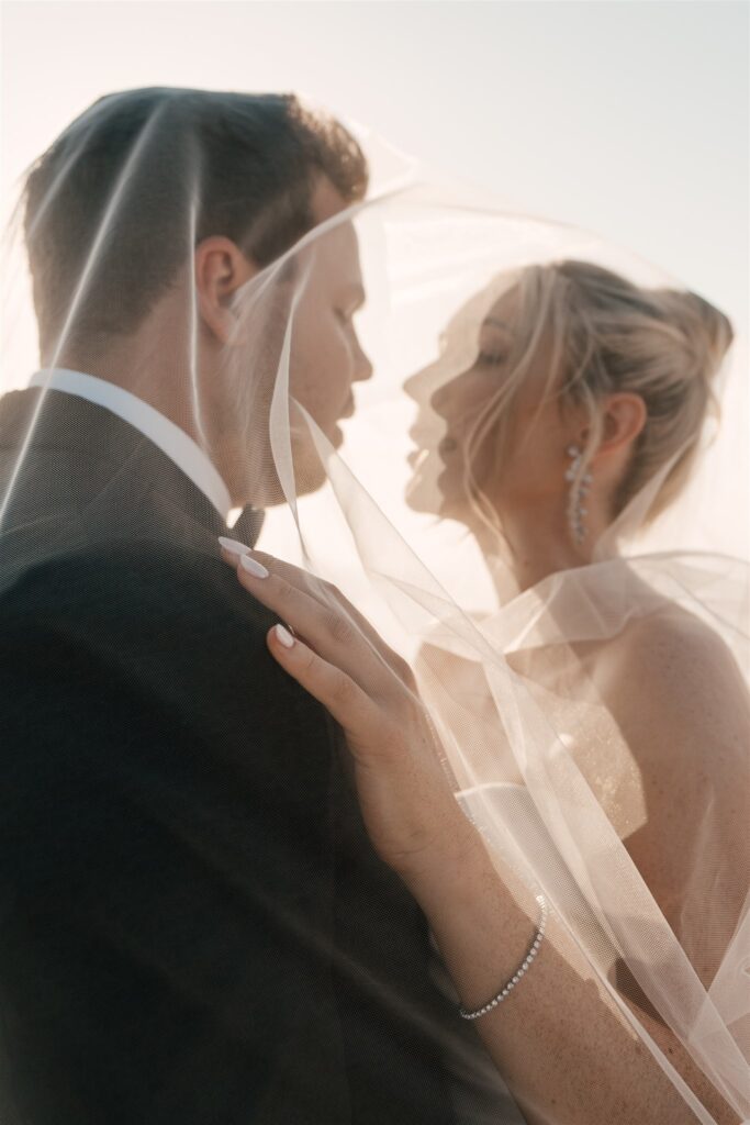 close up couple under wedding vail