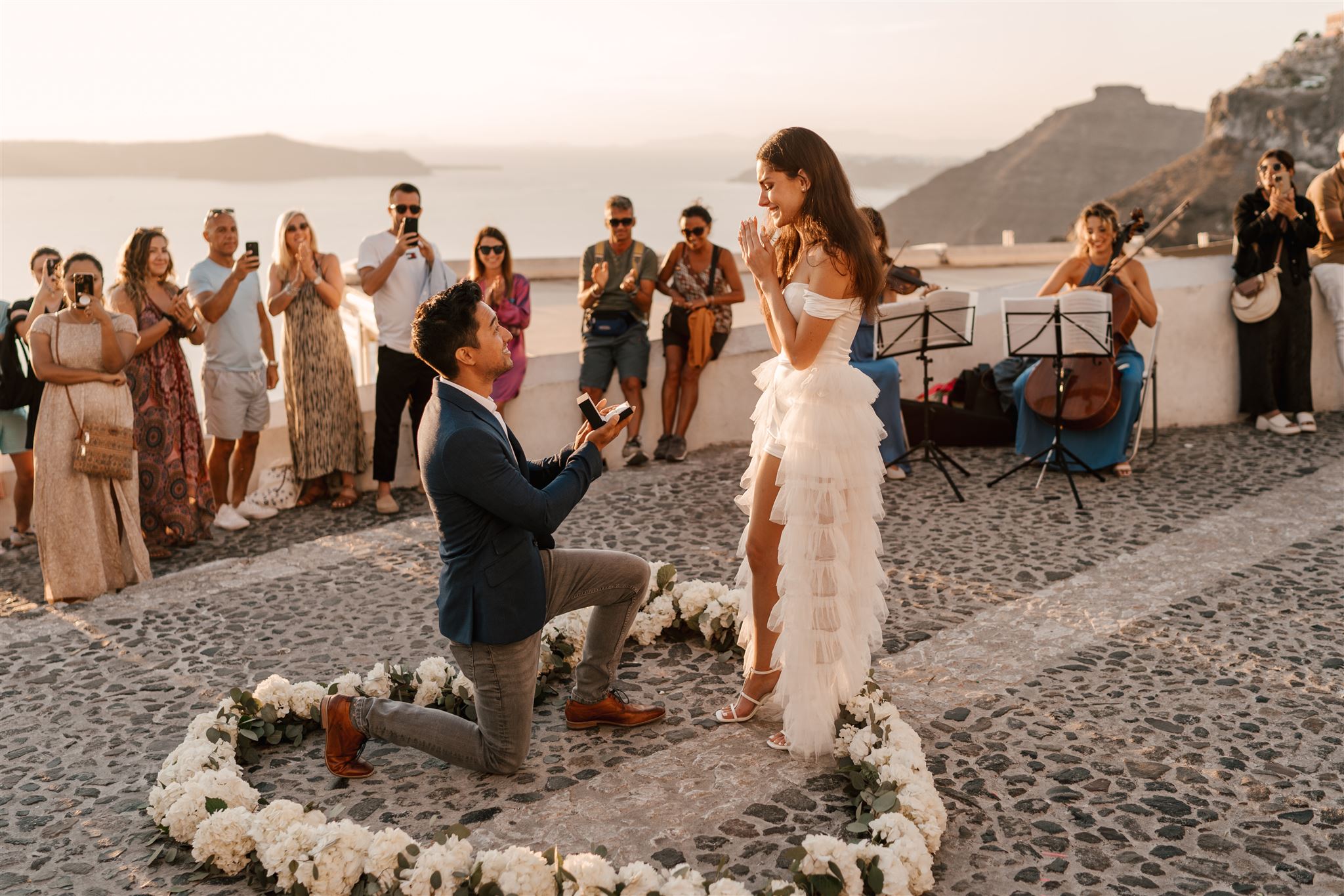 Romantic proposal moment in santorini heart of Flowers and live orchestra at sunset