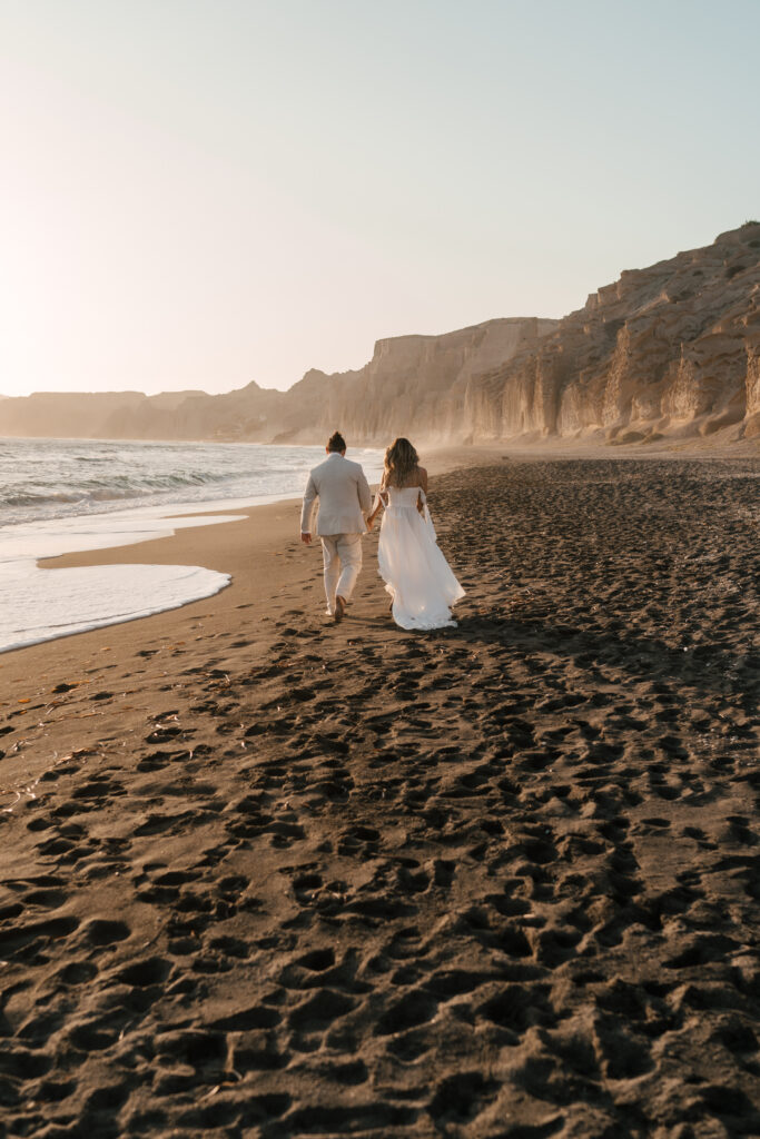 couple walking bearfoot photoshoot santorini beach romantic