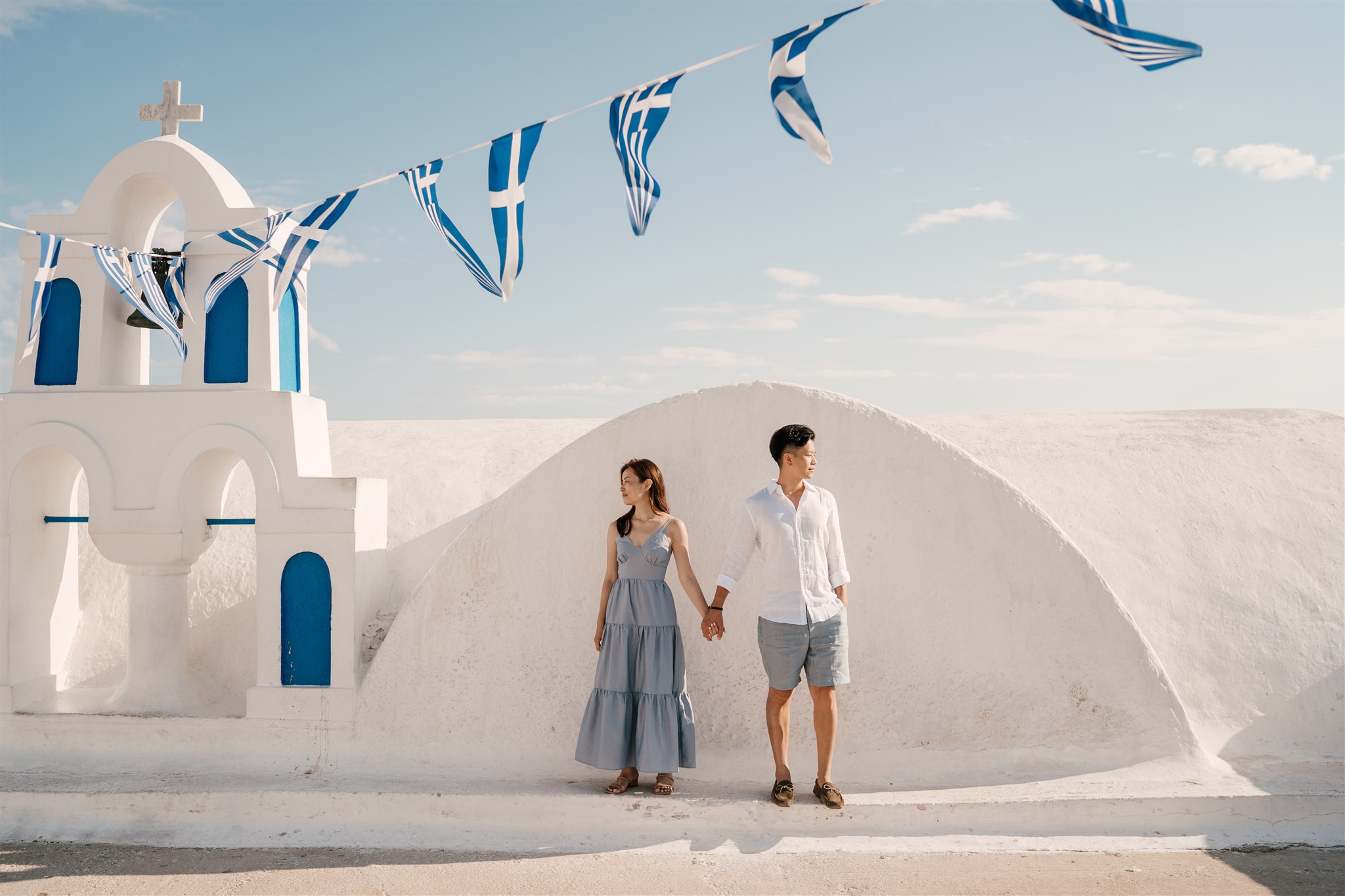 couple next to Blue dome church in Santorini Oia