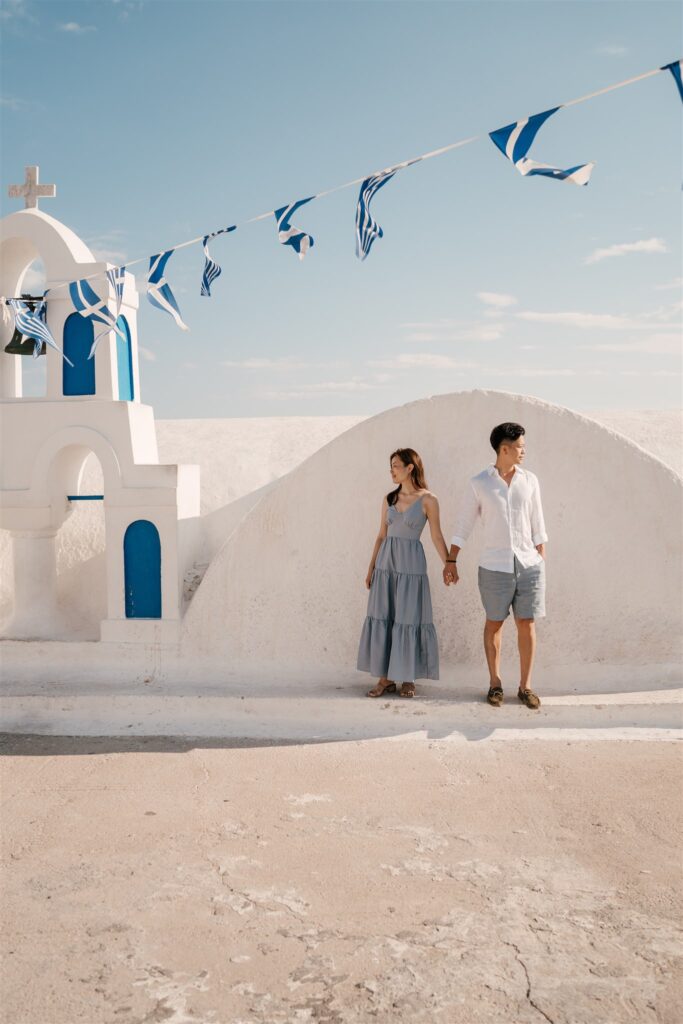 couple next to Blue dome church in Santorini Oia