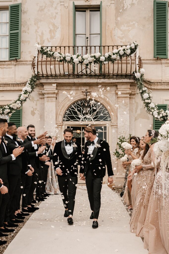 luxury gay wedding couple welcomed with rose petals