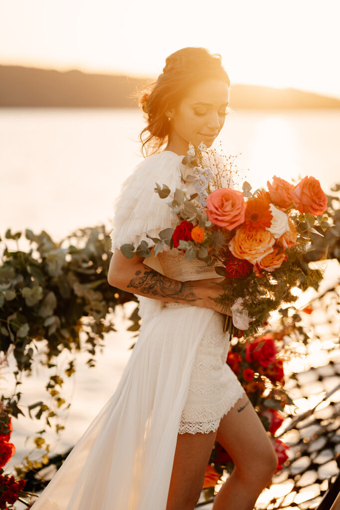 Bride holding her wedding bouquet at sunset in santorini
